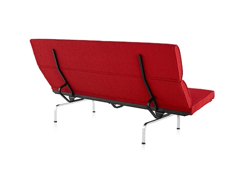 Three-quarter rear view of a red Eames Sofa Compact. 