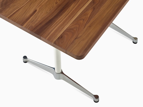 Primer plano de la superficie de una mesa Eames con pata en T en nogal.