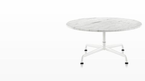 A round Eames outdoor table with a white marble top and white base. 