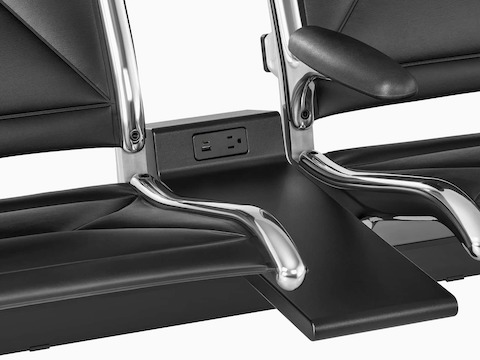 Connected black sling seating with integrated power source that includes USB-C port, USB-A port, and A/C power outlet. Connected black sling seating with integrated power source that includes USB-C port, USB-A port, and A/C power outlet.