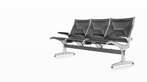 Three connected black sling seats positioned at an angle with integrated power source that includes USB-C port, USB-A port, and AC power outlet. Three connected black sling seats positioned at an angle with integrated power source that includes USB-C port, USB-A port, and AC power outlet.