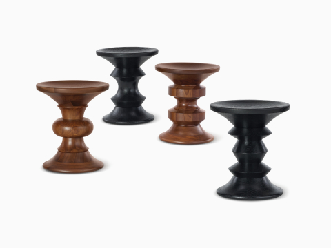 四张 Eames 转动式凳子，形状各异，采用乌木灰和胡桃木饰面。