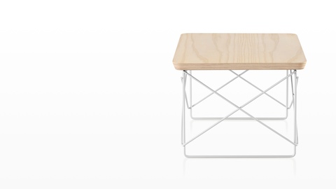An Eames Wire Base Low Table with a white ash veneer top. 
