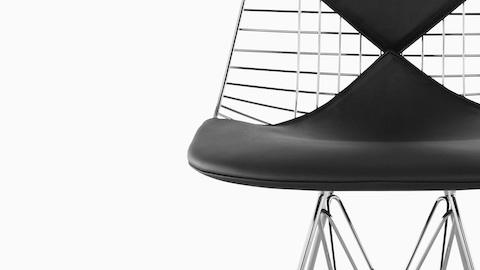 Close-up of the optional two-piece, bikini-style seat pad on an Eames Wire side chair. Close-up of the optional two-piece, bikini-style seat pad on an Eames Wire side chair.