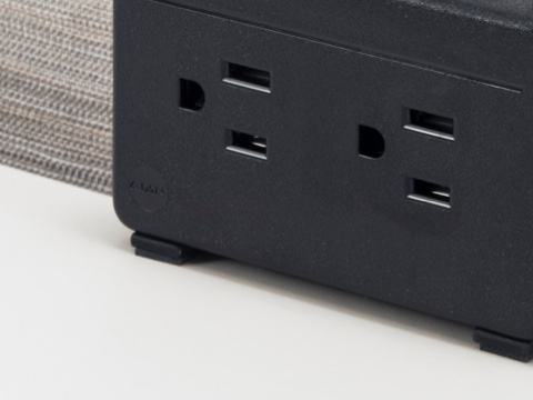 Partial view of a black, two-outlet Connect Electrical Distributor. Partial view of a black, two-outlet Connect Electrical Distributor.