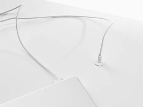 Surface-integrated single port USB-C power solution shown in white charging a laptop.
