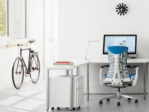 蓝Embody办公椅在一张白色Canvas Office L景观个人工作区。