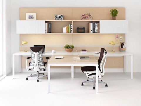 Deux chaises de bureau Embody rouge foncé et un mur d'équipe Canvas Office Landscape avec rangement supérieur.