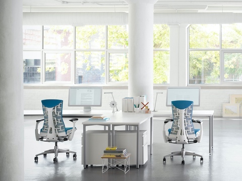 Dos sillas para oficinas Embody en azul en un área blanco de trabajo Canvas Office Landscape.