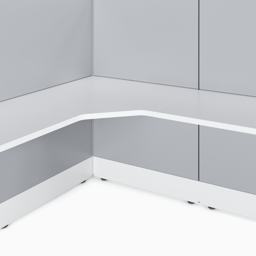 Ethospace wall unit in white trim and light gray tiles and a white solid surface work surface with a focus on the corner surface.