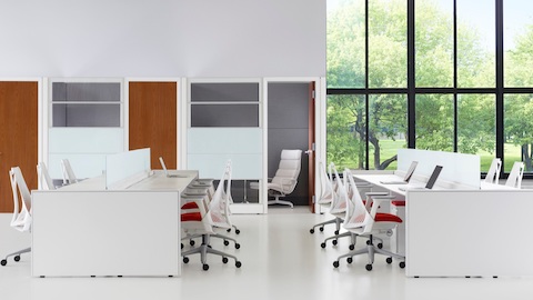 White Sayl desk chairs with red upholstered seats at Ethospace benches in an open office. White Sayl desk chairs with red upholstered seats at Ethospace benches in an open office.