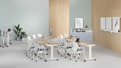 Twee rijen kuipvormige Everywhere-tafels in een leeromgeving, gecombineerd met Caper-stoelen en twee tafels op stahoogte achteraan in de ruimte.