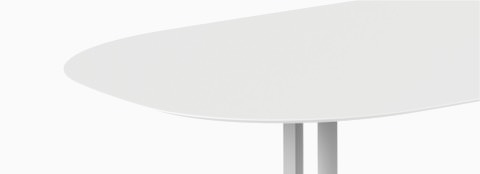 Gros plan d’une table ovale Everywhere blanche, avec piètement gris. Gros plan d’une table ovale Everywhere blanche, avec piètement gris.