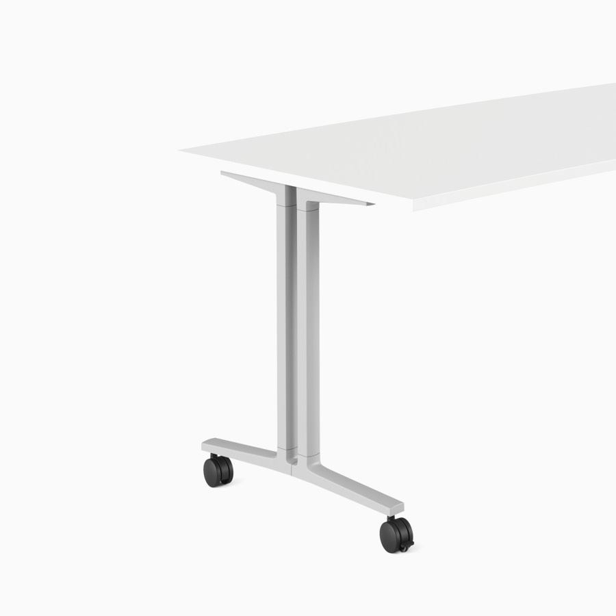 Weißer, gebogener Everywhere Table für Unterrichtsräume mit grauen Beinen und Laufrollen, im Winkel betrachtet.