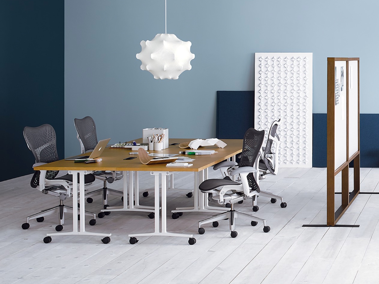 A room with wood surface and white leg Everywhere Tables configured in a workshop setting. 