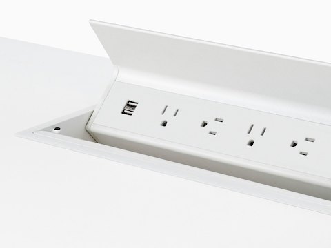 Close view of a pop-up power port integrated into the surface of a white Everywhere Table.