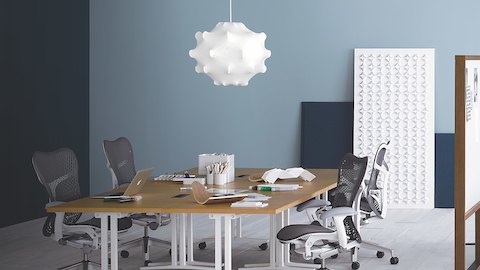 A collaboration space featuring gray Mirra 2 office chairs and four square Everywhere Tables, ganged to form a large meeting table.