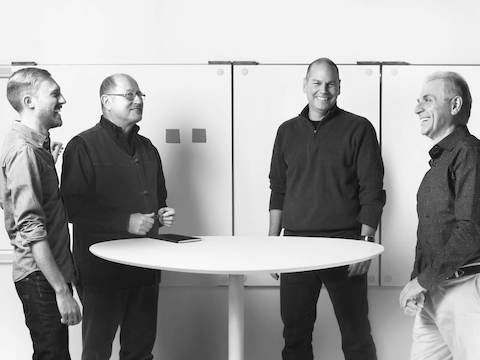 Four product designers from Continuum interact around a table. Four product designers from Continuum interact around a table.