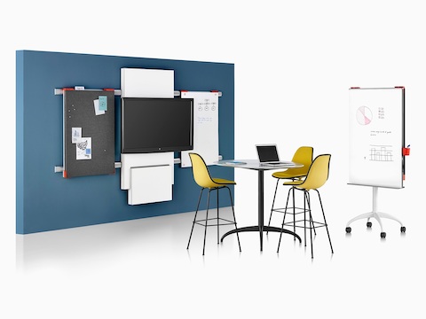A collaboration space featuring a table, media tile, and display boards from Exclave, as well as three yellow stools. A collaboration space featuring a table, media tile, and display boards from Exclave, as well as three yellow stools.