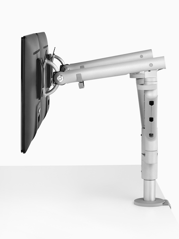 Visão de perfil de monitores lado a lado conectados a um braço de monitor Flo Dual.