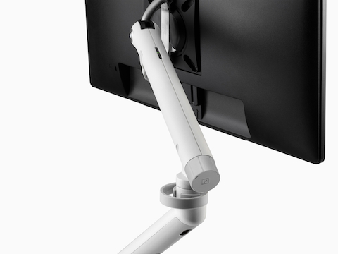 Vista angolare posteriore di un monitor nero fissato a un braccio porta monitor Flo, incluso il regolatore senza utensili opzionale.