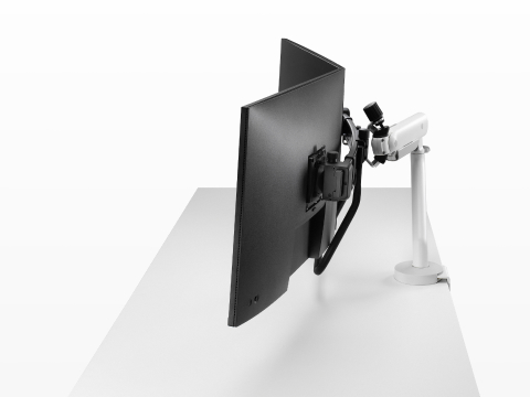 白色 Flo X 双显示器挂臂设置，搭配 32'' 屏幕，侧视图。