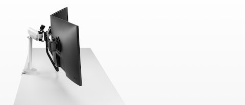 ホワイト、デュアルタイプのフローXモニターアームに32インチスクリーンを取り付けた設置例を側面から見たところ。