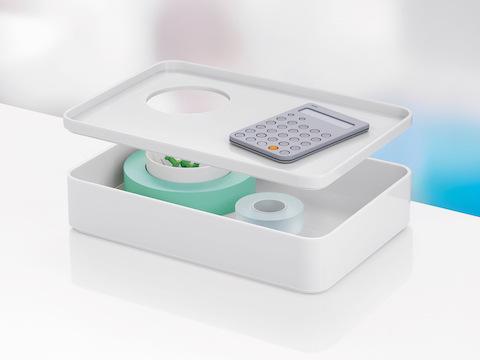 A small white Formwork Box with the removable lid hovering above the storage compartment and enclosed cup. A small white Formwork Box with the removable lid hovering above the storage compartment and enclosed cup.
