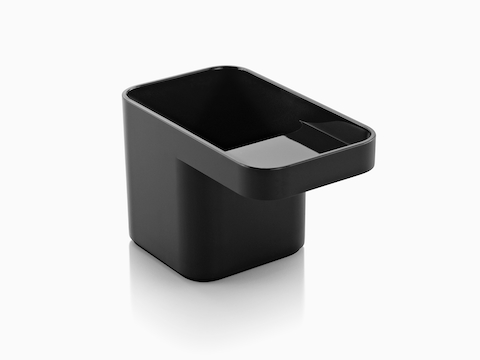 Angled view of a black Formwork Pencil Cup with a deep rear compartment and cantilevered front compartment.