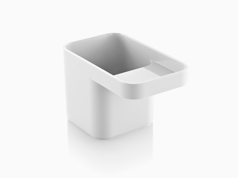 Angled view of a white Formwork Pencil Cup with a deep rear compartment and cantilevered front compartment.