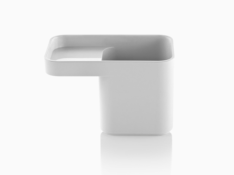Profile view of a white Formwork Pencil Cup with a deep rear compartment and cantilevered front compartment.