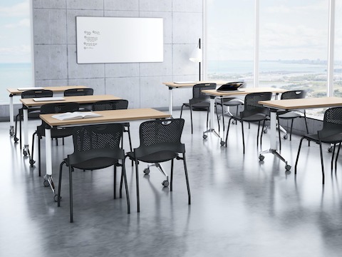 A training room setting featuring a Genus flip-top tables with Caper stacking chairs.