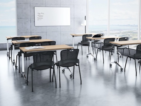 A training room setting featuring a Genus flip-top tables with Caper stacking chairs.
