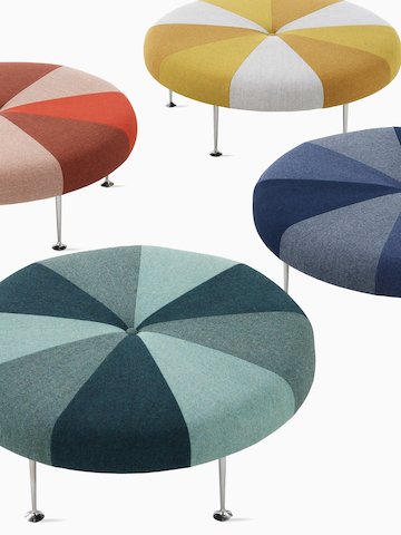 A round Girard Color Wheel Ottoman upholstered in wedges of blue, gray, and white.