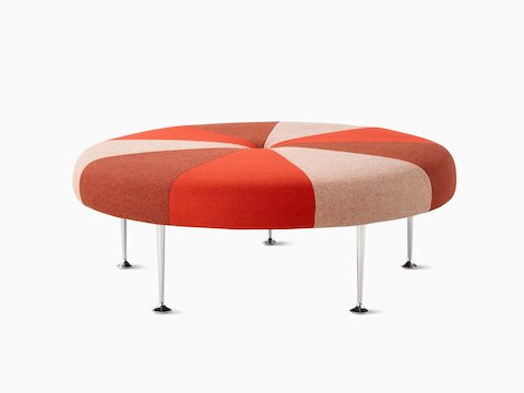 A Girard Colour Wheel Ottoman upholstered in red fabrics, viewed from the side.