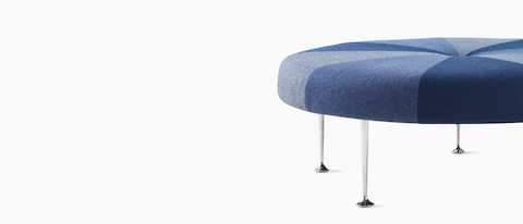 A Girard Colour Wheel Ottoman upholstered in blue fabrics, viewed from the side.