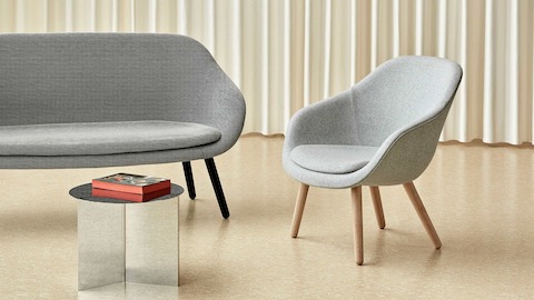A grey About A Lounge Sofa with black legs next to a light grey About A Lounge 82 Chair.