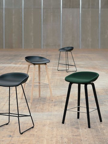 Four different About A Stool variations arranged in large empty room.