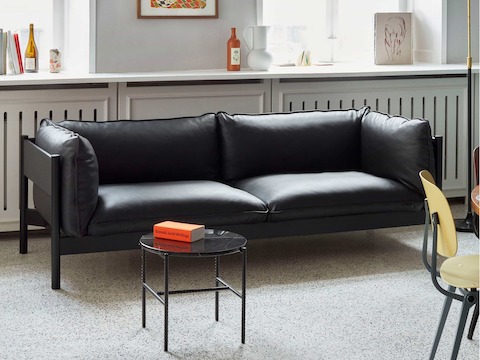 A black leather Arbour Sofa with a black Rebar Side Table.
