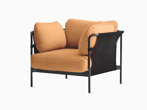 Uma Lounge Chair Can da HAY com estofamento em tecido laranja claro e estrutura preta, vista de frente levemente em ângulo.