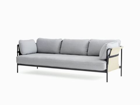 Un sofá Can de tres asientos de HAY con tapicería en tela gris claro y estructura en negro con eslinga en color blanquecino, visto desde un leve ángulo de frente.