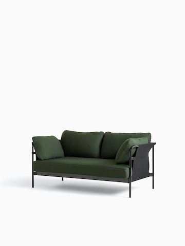 Um sofá Can da HAY de dois lugares, com estofamento em tecido verde e estrutura preta, visto de frente levemente em ângulo.