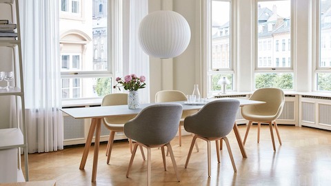 A Copenhague Dining Table with grey About A Chairs around it.
