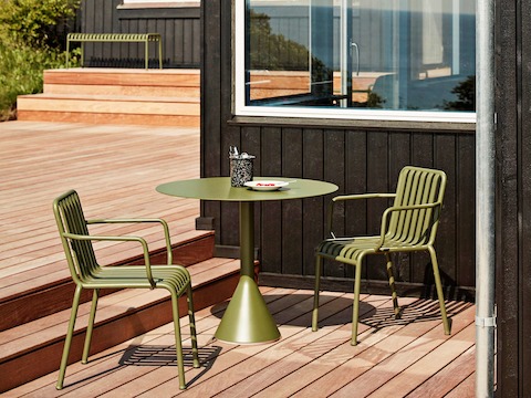 An olive Palissade Bistro Table with two Palissade Chairs outside.
