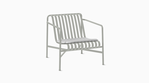 A three quarter view of a Palissade Lounge Chair with Seat Pad in light grey.