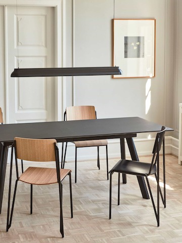 Four Petit Standard Chairs around a black Copenhague Table.