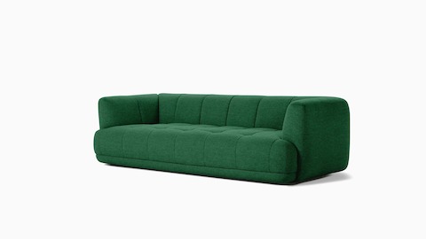A front angle view of an emerald Quilton Sofa.