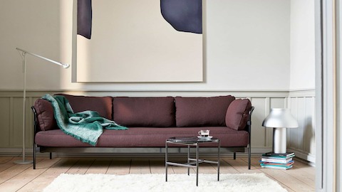 A purple 3-seat Can Sofa with a black frame with a marble Rebar Side Table.