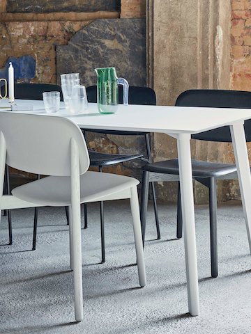 Cadeiras Soft Edge Chairs em branco e preto ao redor de uma mesa Copenhague Deux.