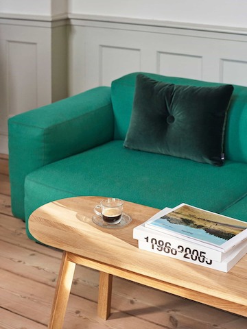 A Triangle Leg Bench in front of a green Mags Low sofa.